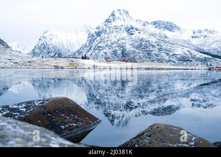 Majestätische Berggipfel, die sich im Winter im eisigen Meer spiegeln, Flakstadpollen, Flakstadoya, Nordland, Lofoten-Inseln, Norwegen, Skandinavien, Europa Stockfoto