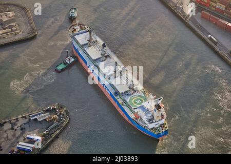 Das Schiff dockt an den Seaforth Docks, Liverpool, an und wird von zwei Schlepper, Merseyside, Nordwestengland, Großbritannien, angefahren Stockfoto