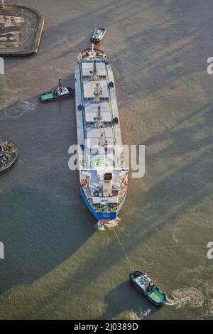 Das Schiff dockt an den Seaforth Docks, Liverpool, an und wird von zwei Schlepper, Merseyside, Nordwestengland, Großbritannien, angefahren Stockfoto