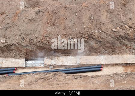 Bauarbeiten. Verlegung einer Pipeline, um Häuser mit heißem und kaltem Wasser zu versorgen. Austausch der alten Pipeline Stockfoto