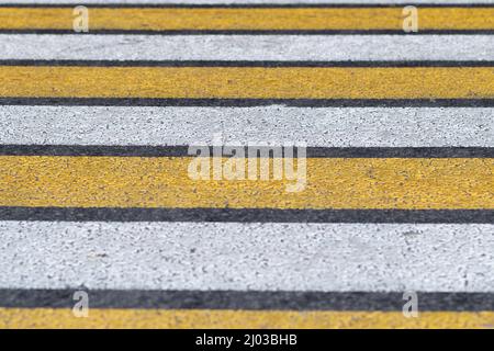 Bezeichnung eines ungeregelten Fußgängerübergangs in Risikogebieten. Fußgänger-Zebra gelb-weiß Stockfoto