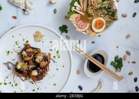 Eine Schüssel mit Ramen-Suppe und ein Teller Takoyaki-Snack Stockfoto