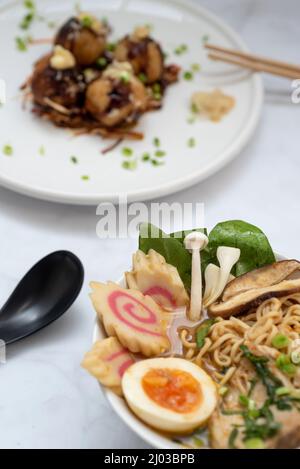 Eine Schüssel mit Ramen-Suppe und ein Teller Takoyaki-Snack Stockfoto