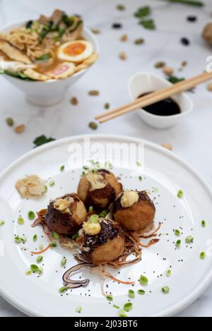 Eine Schüssel mit Ramen-Suppe und ein Teller Takoyaki-Snack Stockfoto