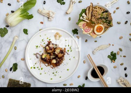 Eine Schüssel mit Ramen-Suppe und ein Teller Takoyaki-Snack Stockfoto
