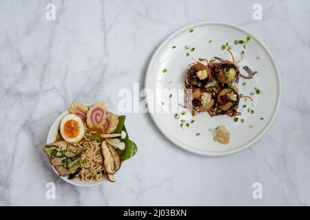 Eine Schüssel mit Ramen-Suppe und ein Teller Takoyaki-Snack Stockfoto