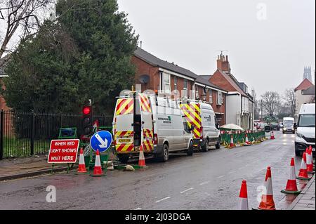 Straßenarbeiten mit grünen Barrieren und Wartungswagen auf der High Street Stockfoto