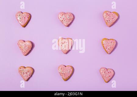Leckere herzförmige Kekse auf rosa Hintergrund Stockfoto