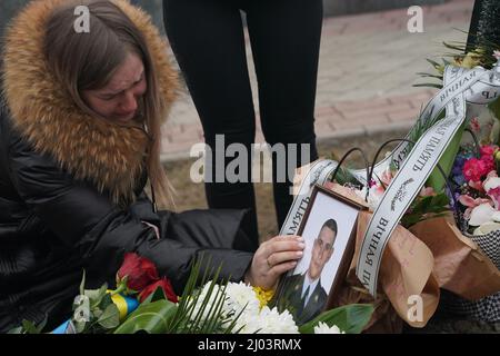 16. März 2022, Lwiw, Ukraine: Ein Familienmitglied berührt ein Foto bei einem Trauerdienst für den ukrainischen Militärleutnant Eduard Pertowitsch Nezehlec, der am 16. März 2022 auf dem Friedhof in Lytschakiv in der westukrainischen Stadt Lwiw getötet wurde. Etwa 30 Raketen wurden teilweise von der ukrainischen Verteidigung abgefangen, aber 9 von ihnen trafen auf den Stützpunkt Javoriv, etwa 20 km von der polnischen Grenze entfernt, der im Februar NATO-Truppen erhielt. 35 Soldaten starben bei dem Angriff, 135 wurden verletzt. (Bild: © Bryan Smith/ZUMA Press Wire) Stockfoto