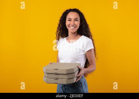 Happy Latin Lady Hält Pizzakisten Im Studio Stockfoto