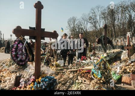 Lviv, Ukraine. 15. März 2022. Familienmitglieder, Freunde und Genossen zollen vier ukrainischen Soldaten, die bei einem russischen Luftangriff auf einer Militärbasis nahe der polnischen Grenze getötet wurden, ihren Respekt. Auf dem Lytschakivske Friedhof in Lemberg versammelten sich Trauersoldaten zur Beerdigung von vier ukrainischen Soldaten; OLEH Yastschyschyn, Sergiy Melnyk, Rostyslaw Romantschuk und Kyrylo Vyschywany, die Anfang der Woche durch einen russischen Luftangriff auf das Internationale Zentrum für Friedenssicherung und Sicherheit, eine Militärbasis in Javoriv in der Nähe der polnischen Grenze, getötet wurden. Kredit: SOPA Images Limited/Alamy Live Nachrichten Stockfoto