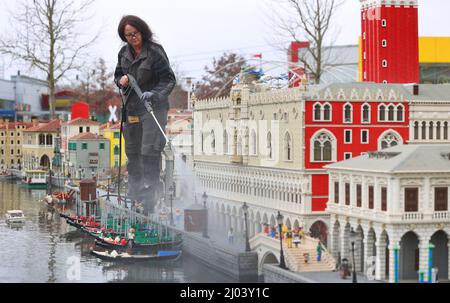 16. März 2022, Bayern, Günzburg: Sonja Hermann, Mitarbeiterin im Freizeitpark Legoland, befreit ein aus Legosteinen nachgestelltes Modell der Stadt Venedig aus Sahara-Staub in Miniland. Etwa zwei Wochen vor Saisonbeginn stellt der Staub die Parkmitarbeiter vor besondere Herausforderungen. Foto: Karl-Josef Hildenbrand/dpa Stockfoto