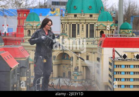 16. März 2022, Bayern, Günzburg: Sonja Hermann, Mitarbeiterin im Freizeitpark Legoland, befreit ein Modell der Stadt Berlin aus Legosteinen aus dem Sahara-Staub in Miniland. Etwa zwei Wochen vor Saisonbeginn stellt der Staub die Parkmitarbeiter vor besondere Herausforderungen. Foto: Karl-Josef Hildenbrand/dpa Stockfoto