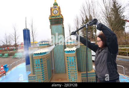 16. März 2022, Bayern, Günzburg: Sonja Hermann, Mitarbeiterin im Freizeitpark Legoland, befreit ein aus Legosteinen repliziertes Modell des Makkah Royal Clock Tower Hotels in Saudi-Arabien aus Sahara-Staub in Miniland. Rund zwei Wochen vor Saisonbeginn stellt der Staub die Parkmitarbeiter vor besondere Herausforderungen. Foto: Karl-Josef Hildenbrand/dpa Stockfoto