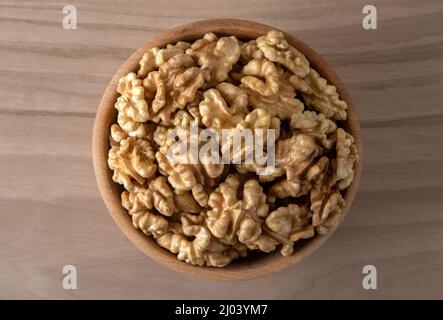 Schüssel voller geschälter Walnüsse auf einem hölzernen Hintergrund, Draufsicht Stockfoto