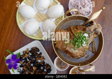 Geschmortes Schweineknöchel mit Soße-Suppe im chinesischen Yunnan-Stil oder in Soße geschmortes Yunnan-Schweinekeul mit Mantou, chinesischem Essen. Stockfoto