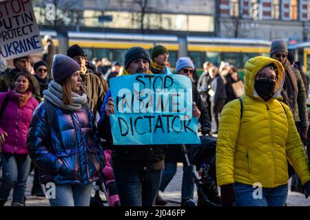 Stoppt den verrückten Diktator. Mann mit blauem Papierbogen gegen den Protest gegen die Invasion der Ukraine in Helsinki, Finnland. Stockfoto