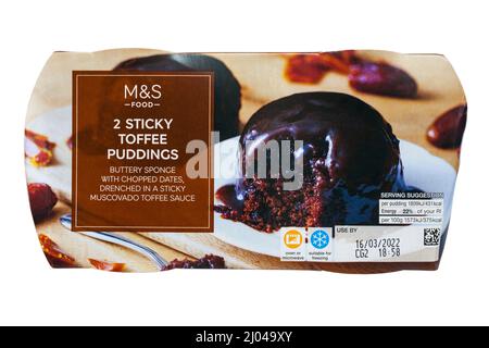 2 Sticky Toffee Puddings von M&S isoliert auf weißem Hintergrund - buttriger Schwamm mit gehackten Datteln, getränkt in einer klebrigen Muscovado-Toffee-Sauce Stockfoto