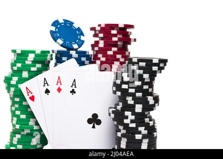 Nahaufnahme von vier Ass Poker Spielkarten zwischen grün rot blau schwarz Stapel von Spielchips auf weißem Hintergrund Konzept für Glücksspiel Poker Turnier Stockfoto