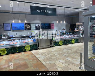 Die Fleisch- und Fischtheke in Waitrose Rushden Northamptonshire UK zeigt Leinwand-Personal und Schilder für Geflügellachs-Krabben Schilder Personal elegant Stockfoto