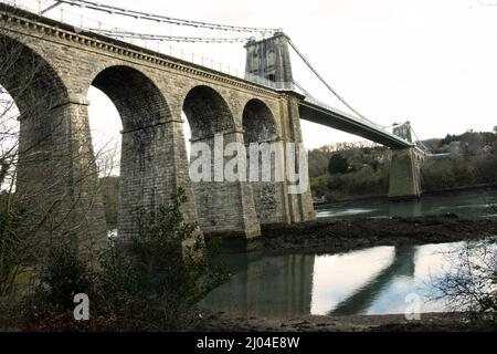 Die 1828 erbaute Hängebrücke über die Menai-Straße wurde vom berühmten Ingenieur Thomas Telford entworfen. Damals war es die längste der Welt Stockfoto