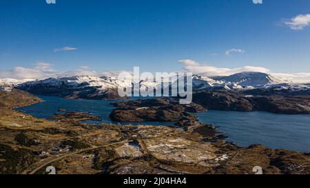 Luftaufnahme der Kylesku Bridge, Loch A Chain Bhain, mit schneebedecktem Assynt im Hintergrund, Highland, Schottland. Stockfoto