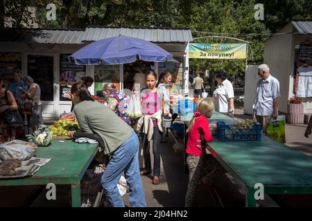 Bild einer Kaufmannin und Verkäuferin in der ukrainischen Stadt Lemberg, die an Ständen verkauft und verhandelt, Obst und Gemüse kauft und verkauft. Stockfoto