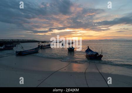 Dramatischer Sonnenaufgang an der Küste von Tanjung Tokong mit Parkplatz für Fischerboote Stockfoto