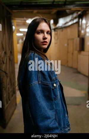 Frau im Denim-Hemd, die in der Mitte des Korridors steht Stockfoto