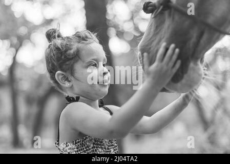 Schwarz Und Weiß Von Little Girl Streichelpferd Stockfoto