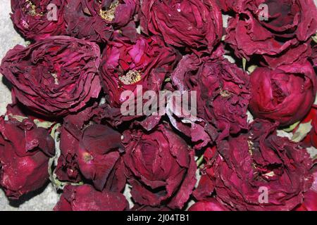 Dunkelrote getrocknete Rose duftende Blütenblätter aus der Nähe, dunkelrote getrocknete Rose Blume auf trockenen duftenden Blütenblättern weichen Hintergrund. Stockfoto