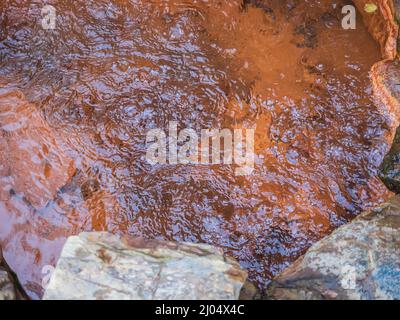 Sprudelndes Mineralwasser aus Mineralquellen im Freien in einem roten felsigen Pool. Heilendes Wasser des Narzans-Tals Stockfoto