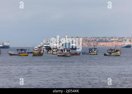 Luanda Angola - 10 13 2021: Blick auf Fischerboote an der Küste der Stadt Luanda, Luanda Bay, mit Hafen von Luanda, Transportschiffe und Container in der Stockfoto