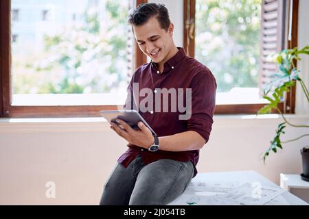 Durch die digitale Landschaft navigieren, um weitere Ideen zu erhalten. Aufnahme eines jungen Geschäftsmannes, der ein digitales Tablet in einem Büro verwendet. Stockfoto