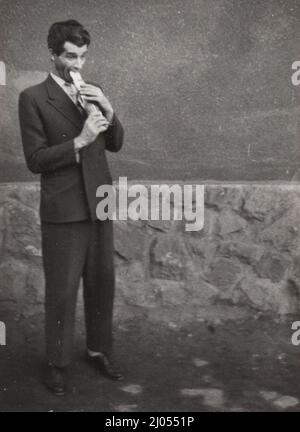 Original Vintage Foto über einen Kartenmagier, der die Karten (Karten aus dem Mund) isst, Karten-Stich aus dem 1930s oder 1940s spielt. Stockfoto