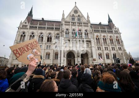 Ungarn, Budapest - MÄRZ 16: Bildungsstreik in Budapest, am 16. März 2022 in Ungarn. Am ersten Tag des Lehrerstreiks demonstrierten die Schüler heute vor dem ungarischen parlament. Mehrere junge Menschen mit Fahnen halten während einer Demonstration ein Plakat. Auf der Tafel steht: „Dummes Land.“ die Gehälter der ungarischen Lehrer erreichen nicht die Höhe des ungarischen Mindestlohns, deshalb erklärt die Lehrergewerkschaft für eine unbestimmte Zeit einen Streik aus. Quelle: Gabriella Barbara/ Alamy Live News Stockfoto