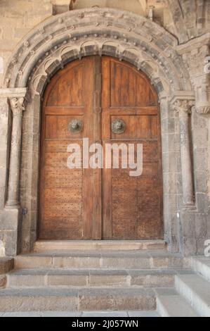 Kreuzgang, Kathedrale unserer Lieben Frau, Le Puy-en-Velay, Auvergne, Haute Loire, Frankreich. Tür, die vom Kreuzgang mit fein geschnitztem Steinumrandung führt. Stockfoto