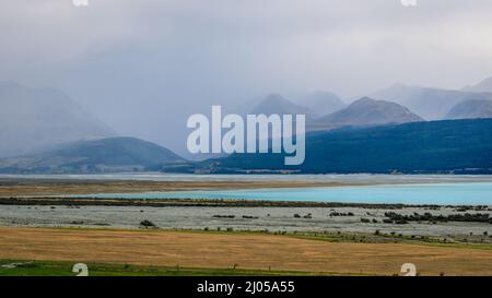 Wunderschöne Aussicht auf den Pukaki-See und die Berge unter dem wolkigen Himmel in Neuseeland Stockfoto