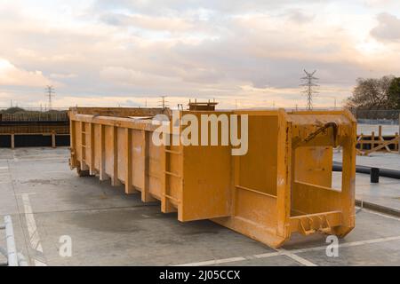 Großer, riesiger leerer Müllcontainer aus Metall auf einer Baustelle. Stockfoto