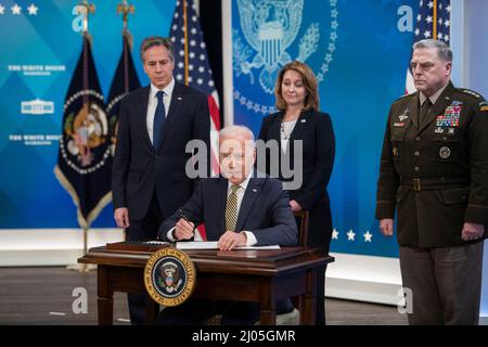 US-Präsident Joe Biden wird von links begleitet: US-Außenminister Antony Blinken, Kathleen Hicks, stellvertretende Verteidigungsministerin der Vereinigten Staaten, und US-Armeegeneral Mark A. Milley, Vorsitzender der Joint Chiefs of Staff, als er am Mittwoch, den 16. März 2022, im Auditorium des South Court des Eisenhower Executive Office Building auf dem Campus des Weißen Hauses in Washington, DC, ein Gesetz über die Unterstützung unterzeichnet, die die Vereinigten Staaten der Ukraine leisten. Quelle: Rod Lampey/CNPhe Staatssekretär Antony Blinken, Biden, stellvertretende Verteidigungsministerin Kathleen Hicks und Vorsitzender Stockfoto