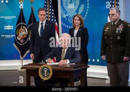 US-Präsident Joe Biden wird von links begleitet: US-Außenminister Antony Blinken, Kathleen Hicks, stellvertretende Verteidigungsministerin der Vereinigten Staaten, und US-Armeegeneral Mark A. Milley, Vorsitzender der Joint Chiefs of Staff, als er am Mittwoch, den 16. März 2022, im Auditorium des South Court des Eisenhower Executive Office Building auf dem Campus des Weißen Hauses in Washington, DC, ein Gesetz über die Unterstützung unterzeichnet, die die Vereinigten Staaten der Ukraine leisten. Quelle: Rod Lampey/CNPhe Staatssekretär Antony Blinken, Biden, stellvertretende Verteidigungsministerin Kathleen Hicks und Vorsitzender Stockfoto