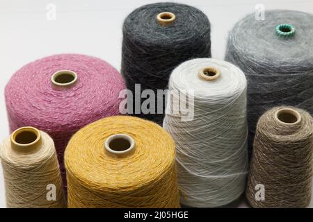 Buntes Garn auf Spule in der Strickfabrik. Garn auf Rohr, Baumwolle, Wolle, Leinenfaden. Stockfoto