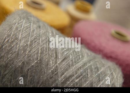 Buntes Garn auf Spule in der Strickfabrik. Garn auf Rohr, Baumwolle, Wolle, Leinenfaden. Stockfoto
