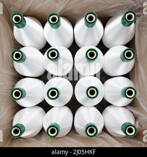 Spulen mit weißem Nylonfaden. Das Polyamid, das für die Herstellung von Nylonhosiery verwendet wird. Stockfoto