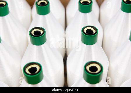 Spulen mit weißem Nylonfaden. Das Polyamid, das für die Herstellung von Nylonhosiery verwendet wird. Stockfoto