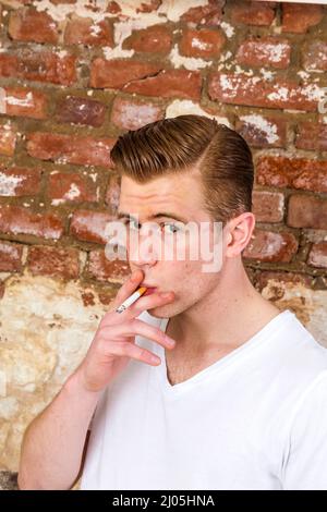 Teenager mit roten Haaren smoks eine Zigarette Stockfoto