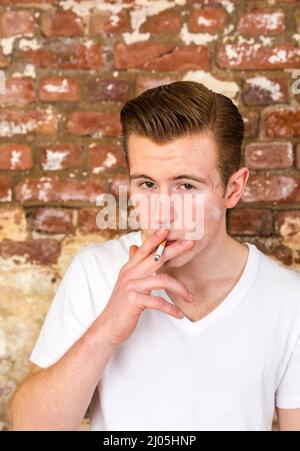 Teenager mit roten Haaren smoks eine Zigarette Stockfoto