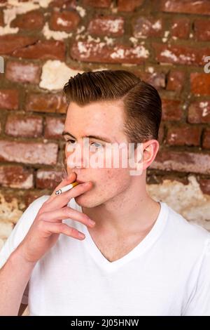 Teenager mit roten Haaren smoks eine Zigarette Stockfoto