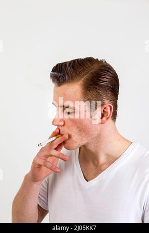 Teenager mit roten Haaren smoks eine Zigarette Stockfoto