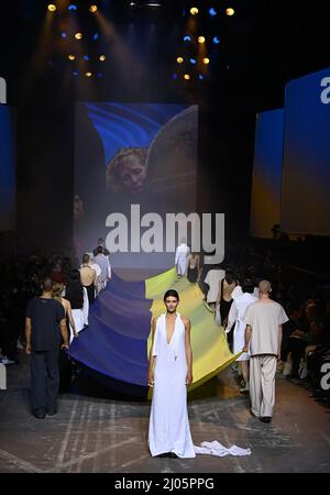 Berlin, Deutschland. 16. März 2022. Berlin Fashion Week: Im Kraftwerk Berlin präsentieren Models Kreationen des ukrainischen Designers Jean Gritsfeldt mit ukrainischer Flagge. Da er nicht nach Berlin kommen kann und auch die Kollektion nicht geliefert werden kann, haben Freiwillige seine Entwürfe neu zugeschnitten, damit sie gezeigt werden können. Quelle: Jens Kalaene/dpa-Zentralbild/dpa/Alamy Live News Stockfoto